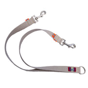 Tan undyed and nature hemp Canva leash splitter for dogs with fluorescent orange reflective tabs at all ends, yellow kevlar stitching and shiny silver metal hardware. pictured with white backdrop.