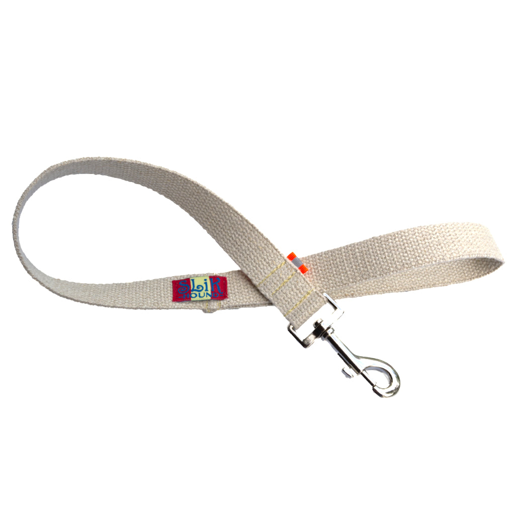 A 2-foot hemp traffic leash Tan undyed and nature hemp Canvas for dogs with fluorescent orange reflective tabs at all ends, yellow kevlar stitching and shiny silver metal hardware. pictured with white backdrop.